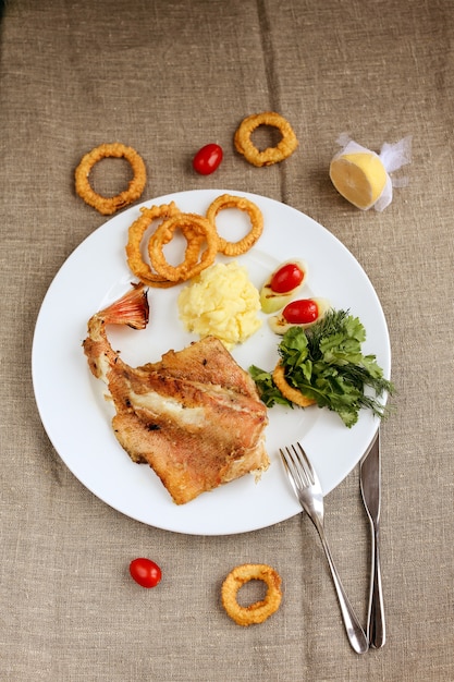 Peixe com anéis de cebola e rosemarry