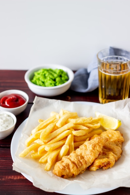 Peixe com batatas fritas em um de madeira. fast-food britânico. receitas. lanche de cerveja. cozinha inglesa.