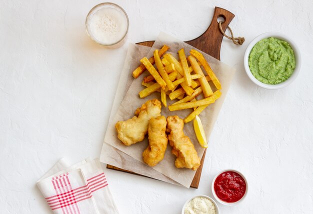 Peixe com batatas fritas em uma mesa branca. Fast food britânico. Receitas Lanche para cerveja. Comida tradicional britânica.