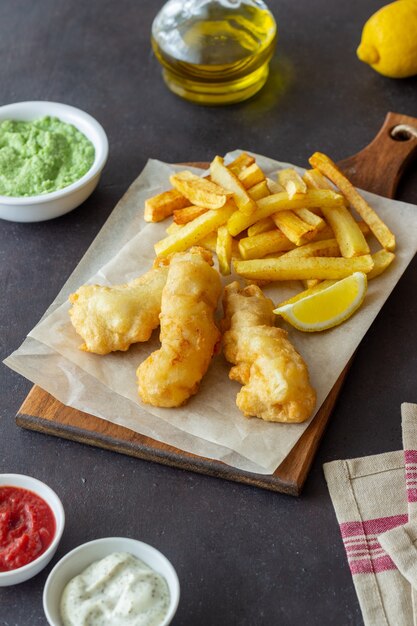 Peixe com batatas fritas em uma mesa escura. Fast food britânico. Receitas Lanche para cerveja. Comida tradicional britânica.