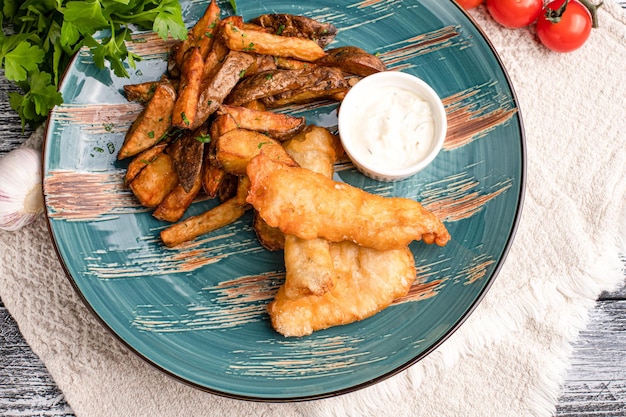 Peixe com batatas fritas Peixe com batatas fritas lanche em um fundo branco de madeira