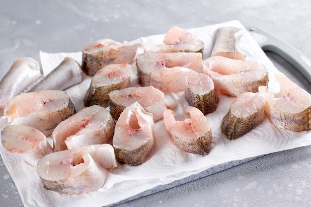 Peixe congelado em uma placa de corte em uma mesa de luz. Alimentos congelados