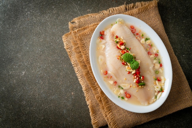 Peixe cozido no vapor em molho de limão picante na chapa branca