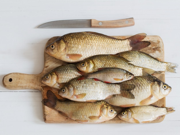 Peixe cru do rio na mesa de madeira