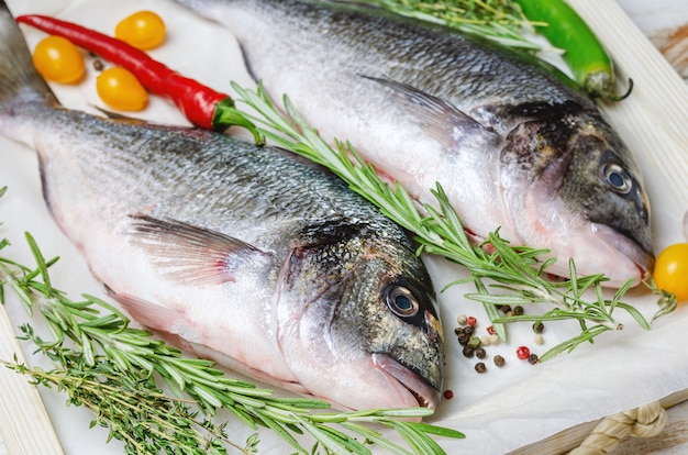 Peixe cru dorado com ervas preparadas para cozinhar