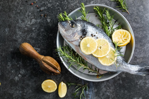 Peixe cru dorado com especiarias Dorado e ingredientes para cozinhar em uma mesa