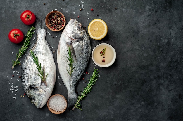 Peixe cru dorado com especiarias e ingredientes tomate, razmorin, óleo de girassol, limão em um fundo de pedra com espaço de cópia para o seu texto