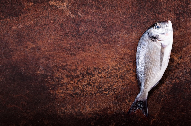 Peixe cru no fundo escuro vintage.