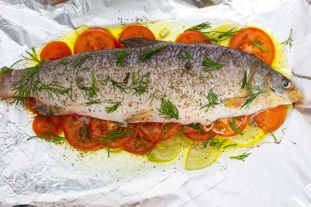 Foto peixe cru preparado para fritar, chokur deitado sobre uma folha com vegetais
