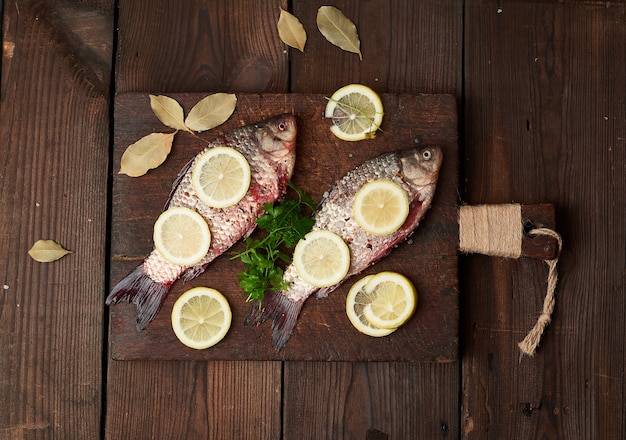Peixe crucian fresco polvilhado com especiarias e rodelas de limão