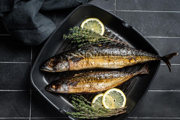 Peixe de cavala grelhado com ervas de limão e especiarias em uma frigideira Fundo preto Vista superior