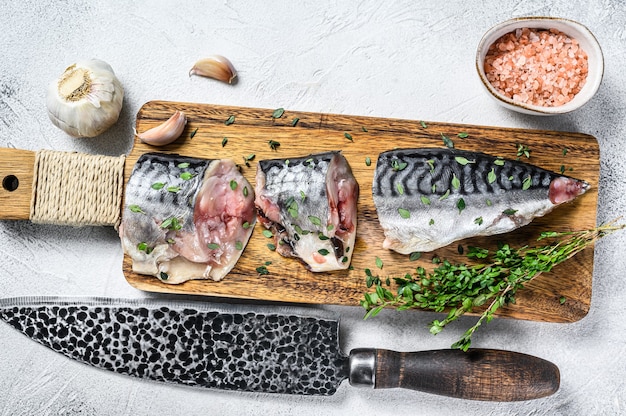 Peixe de cavala salgada fatiada em uma tábua de madeira.