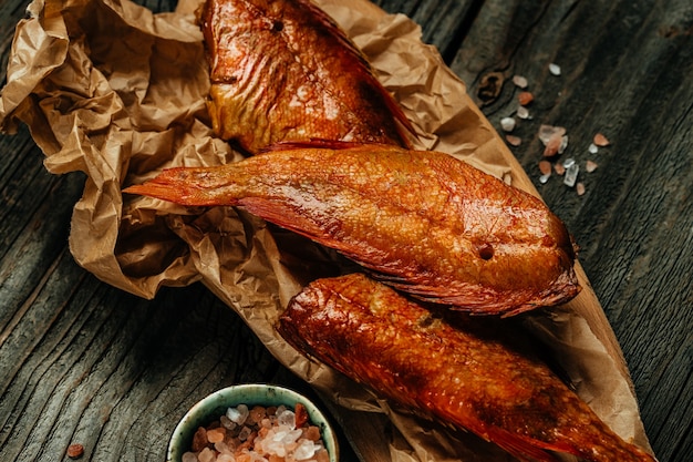 Peixe de peixe defumado caseiro na tábua de madeira. Fundo de receita de comida. Fechar-se,