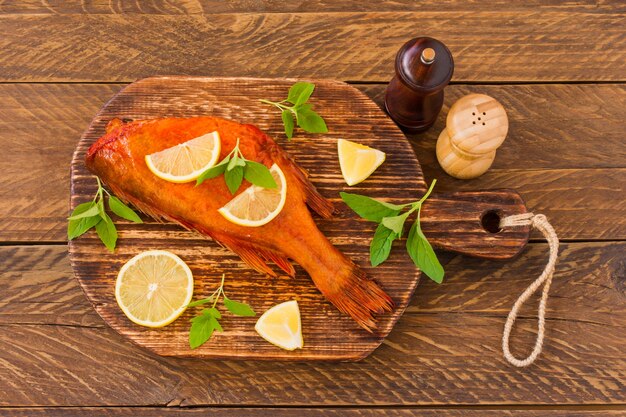 Peixe defumado delicioso oceano poleiro na tábua de madeira para alimentos saudáveis, dieta ou conceito de culinária, foco seletivo.