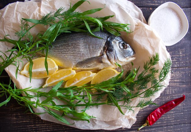 Peixe dourado com limão, endro, alecrim e pimenta malagueta preparada para cozinhar