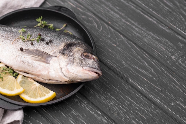 Foto peixe dourado fresco no prato com limão