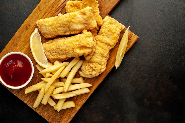 Peixe e batatas fritas com batatas fritas no fundo de pedra