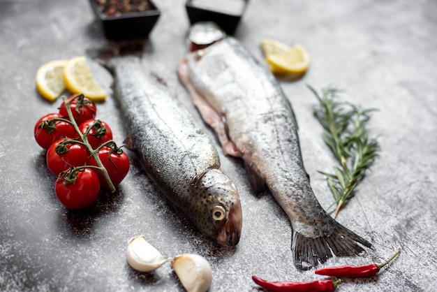 Peixe em uma mesa com tomate, alho e tomate