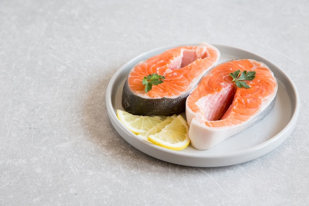 Peixe fresco. bifes de salmão fresco com limão em um prato leve