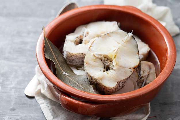 Peixe fresco cozido em panela de cerâmica marrom