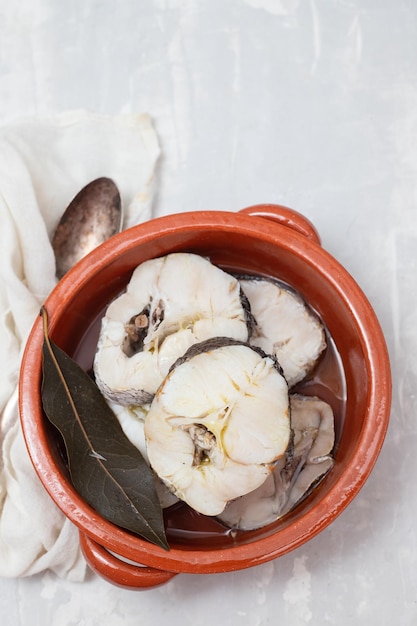 Peixe fresco cozido em panela de cerâmica marrom