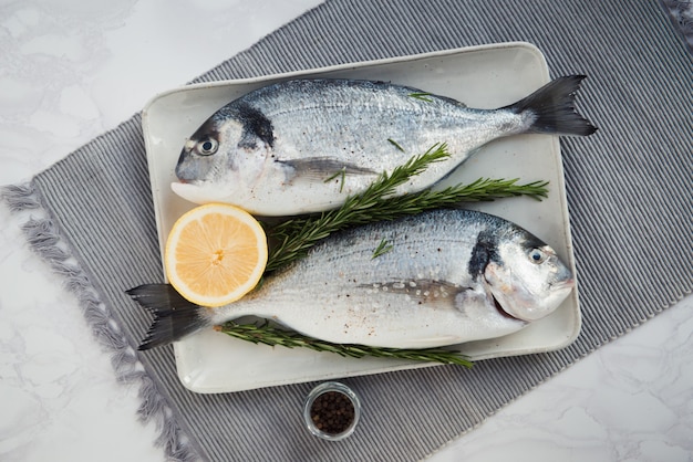 peixe fresco cru dorado com limão, sal e papper