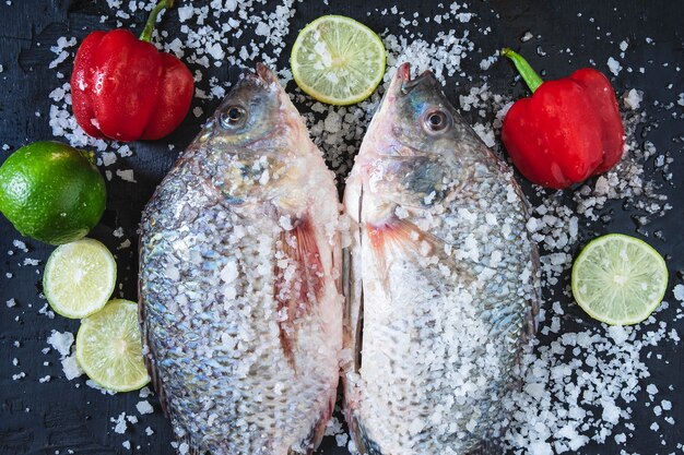 Peixe fresco de tilápia com sal e tempero para cozinhar.