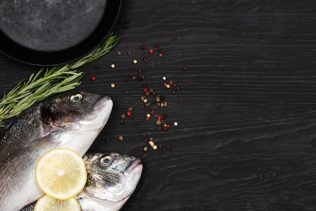 Peixe fresco Dorado Dorado e ingredientes para cozinhar em uma mesa