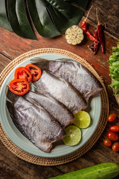 Peixe fresco na mesa guarnecido com legumes