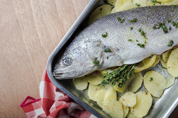 Foto peixe fresco robalo cru preparado para assar com batatas