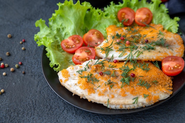 Peixe frito em um prato com alface e tomate cereja closeup Proteínas alimentares saudáveis vitaminas de fibra ômega