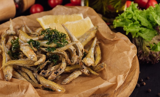 Peixe frito quente com sal e ervas em papel castanho