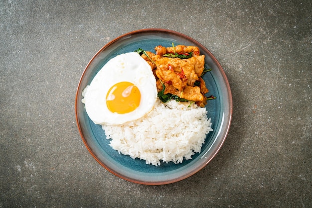 peixe frito salteado com manjericão e ovo frito coberto com arroz - estilo de comida asiática