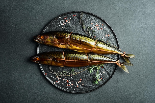 Peixe fumado apetitoso na prancha da cozinha, cabra fumada num prato de ardósia preta.