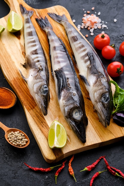 Peixe-gelo fresco cru na tábua de madeira com especiarias e ervas