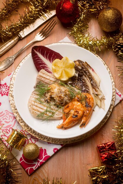 Peixe grelhado misto com chicória vermelha sobre a mesa de natal