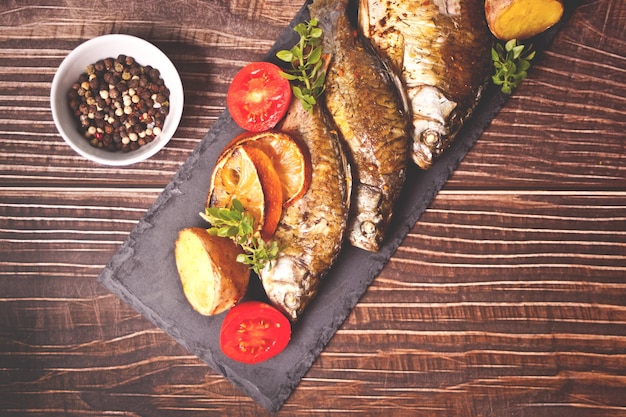 Peixe grelhado no prato com limão e vegetais