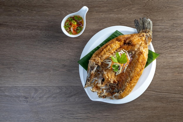 Foto peixe-marinho frito com molho de peixe doce