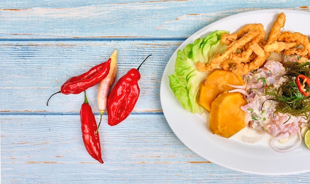 Peixe peruano ceviche e chicharron de pescado com mandioca frita, milho doce e batata doce