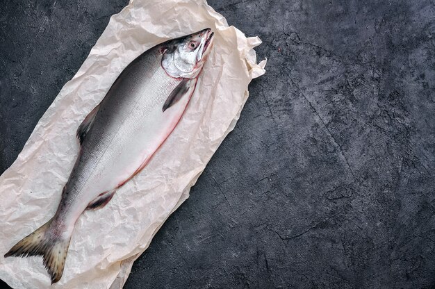 Peixe salmão cru na mesa de pedra escura