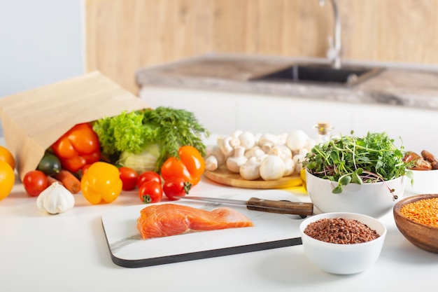 Peixe vermelho e vários vegetais na cozinha