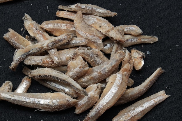Peixes de anchovas ou ikan teri na Indonésia em fundo preto isolado