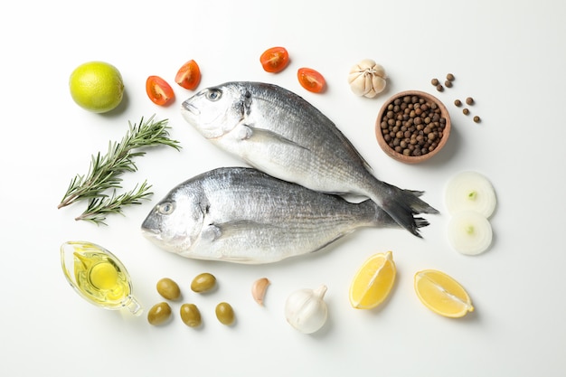 Peixes dorado frescos, especiarias e ingredientes de cozinha em branco