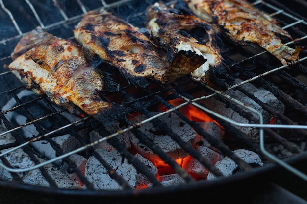 Peixes grelhados com briquetes de carvão quente