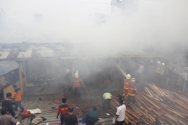 Pekanbaru Indonesia 1 de agosto de 2015 Los bomberos intentan extinguir un incendio que envuelve a una comunidad