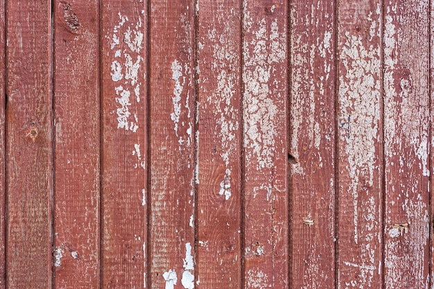 Peladura de pintura blanca sobre pintura marrón en tablones verticales fondo y textura de tablero de madera plana