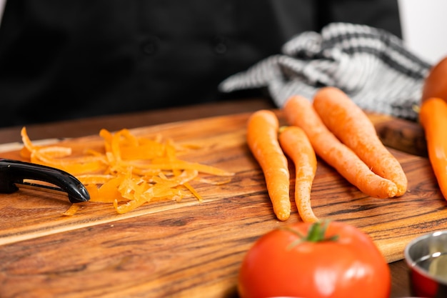 Foto pelar zanahorias orgánicas para hacer sopa de remolacha.