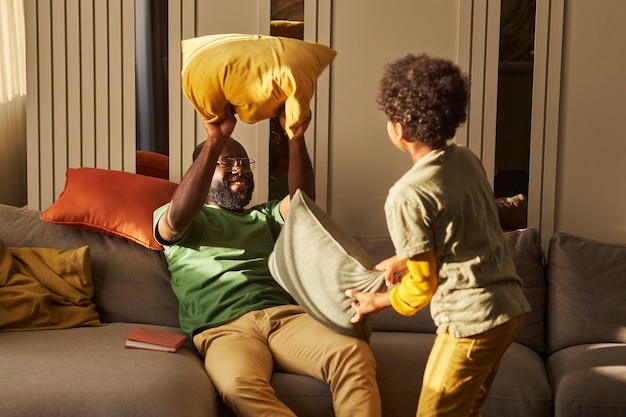 Foto pelea de almohadas de padre e hijo de tiro medio