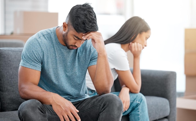 Foto pelea de pareja y ruptura del hombre que se siente deprimido en el sofá de la sala con un problema de relación divorcio habla trampa ansiedad y crisis matrimonial de los jóvenes en el sofá del salón en casa pensando