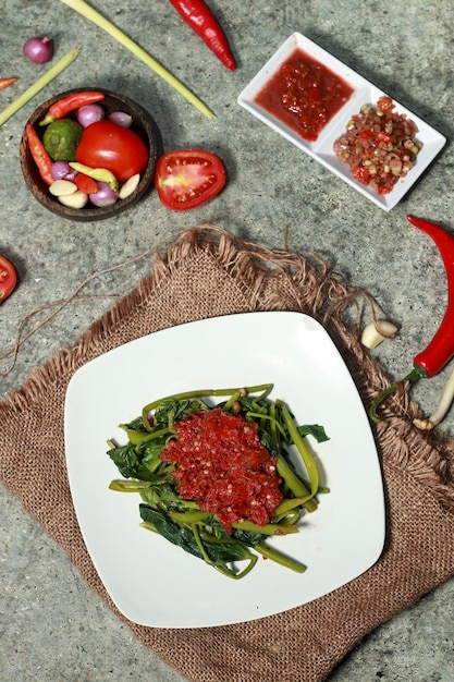 Pelecing Kangkung Typisches indonesisches Lombok-Essen mit würzigen und frischen roten Chilis